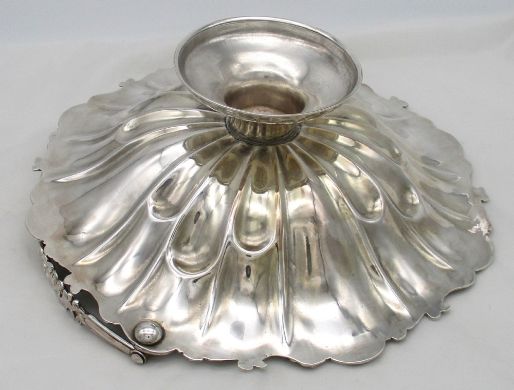 A 19th-century silver-plated bread basket featuring a fluted rim, floral engraving, pedestal base, and an arched swing handle. View VIII