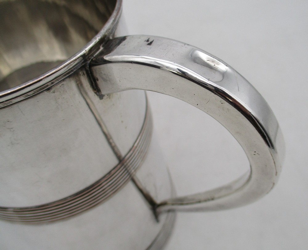 A Georgian silver-plated cylindrical tankard featuring reeded horizontal banding and a curved handle. View V