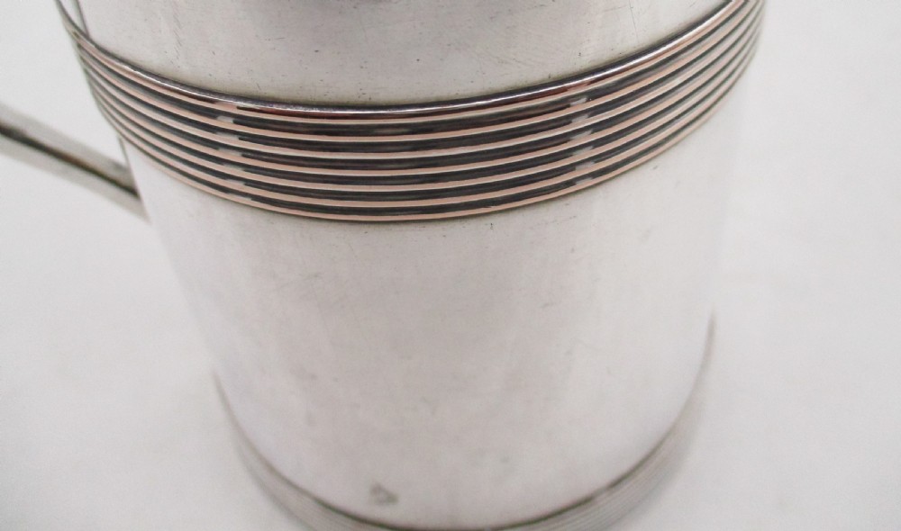 A Georgian silver-plated cylindrical tankard featuring reeded horizontal banding and a curved handle. View VII