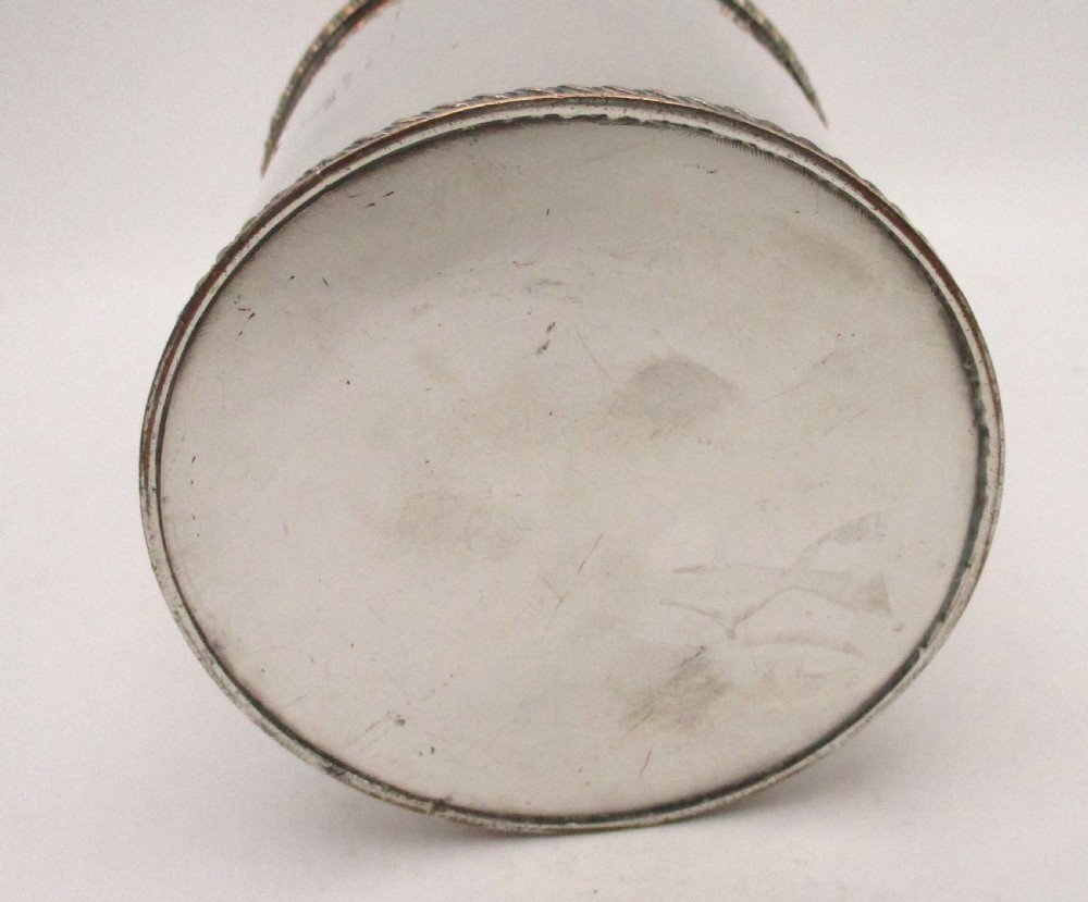 A circular Regency Old Sheffield plated tea caddy featuring a cylindrical silver body with gadrooned rope-twist borders and a fitted cap lid. View V