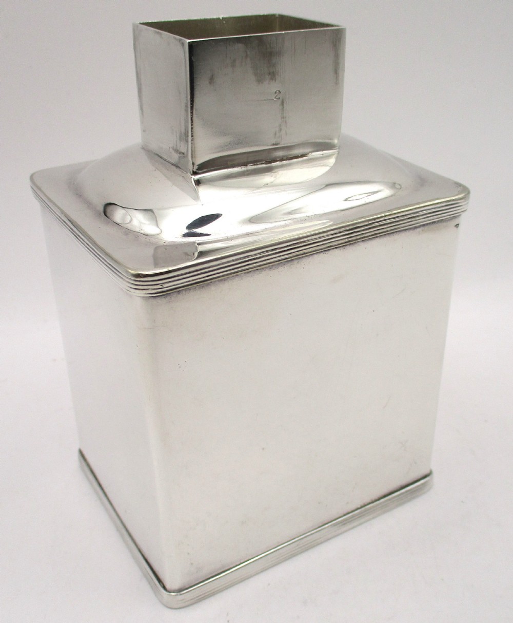 A polished silver-plated square tea caddy featuring stepped reeded borders and a raised rectangular lid. View II
