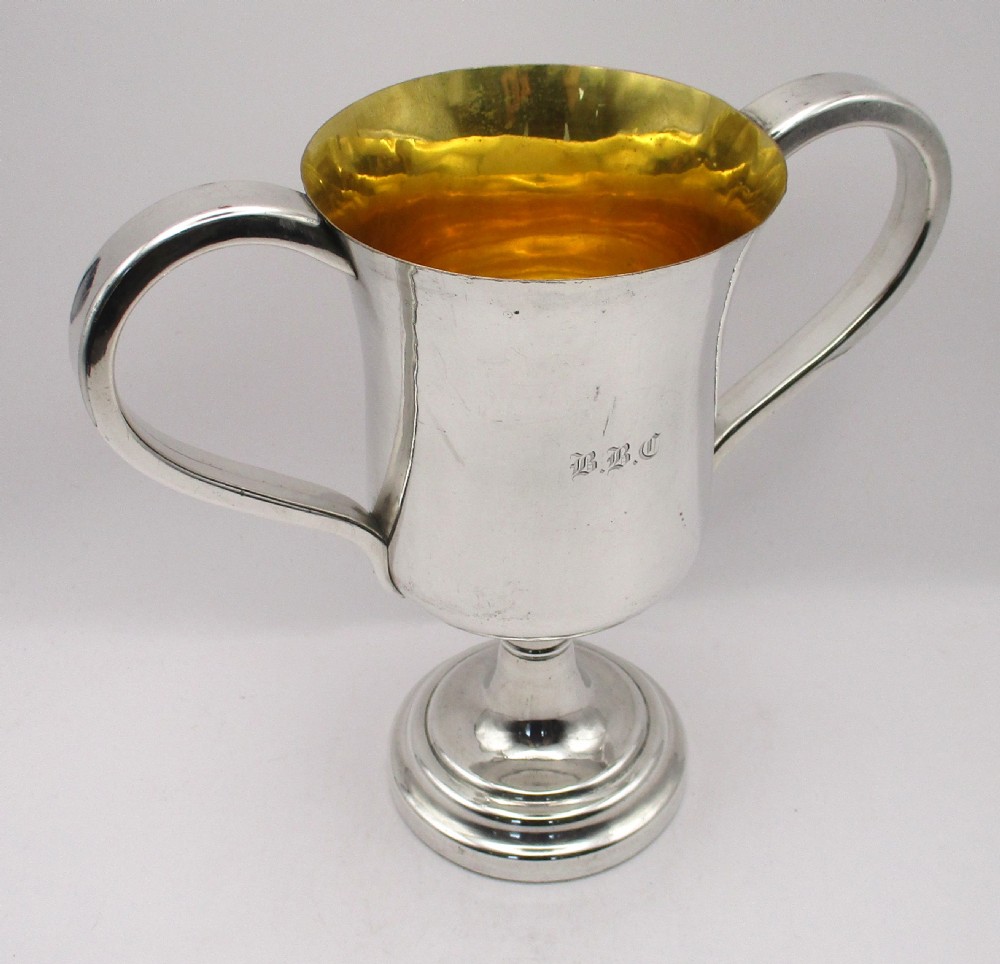 A 19th-century silver-plated two-handled loving cup with a gilt interior and central monogram engraving on a stepped circular pedestal base. View V