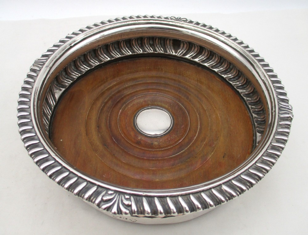 A pair of Georgian Old Sheffield Plated wine coasters featuring turned wooden bases with silver central bosses and gadrooned metal rims. View III