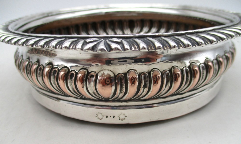 A pair of Georgian Old Sheffield Plated wine coasters featuring turned wooden bases with silver central bosses and gadrooned metal rims. View IV