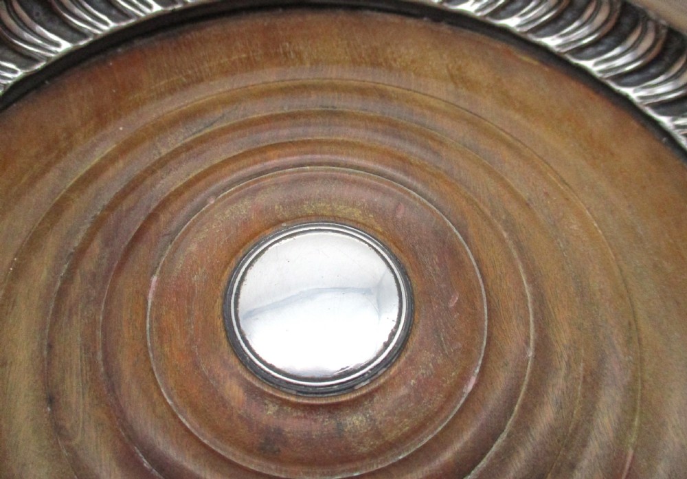 A pair of Georgian Old Sheffield Plated wine coasters featuring turned wooden bases with silver central bosses and gadrooned metal rims. View V