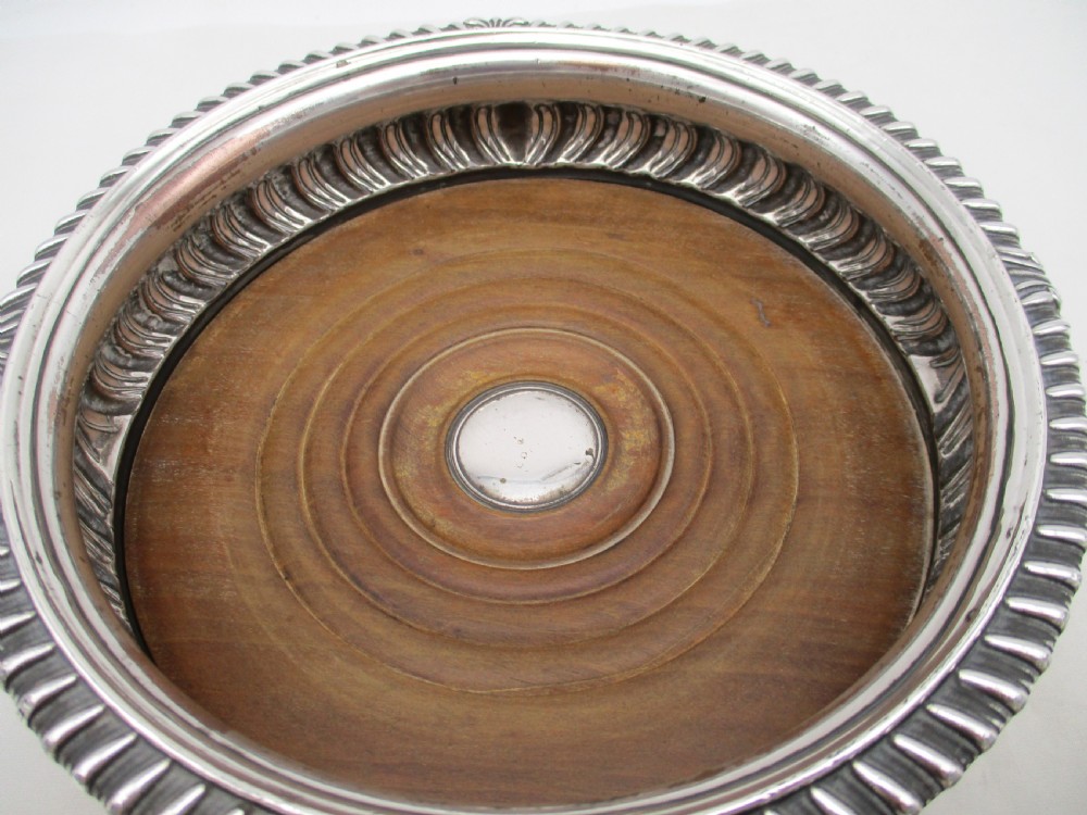 A pair of Georgian Old Sheffield Plated wine coasters featuring turned wooden bases with silver central bosses and gadrooned metal rims. View VII