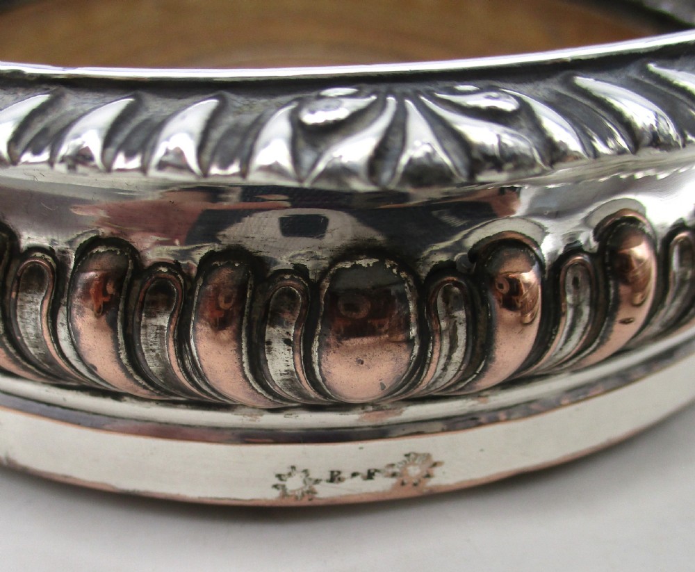 A pair of Georgian Old Sheffield Plated wine coasters featuring turned wooden bases with silver central bosses and gadrooned metal rims. View VIII