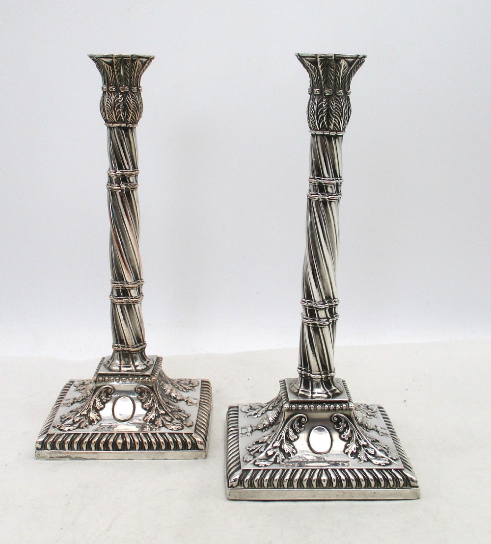 A pair of silver-plated taper candlesticks featuring spiral-fluted columns, foliage capitals, and decorative square bases. View II