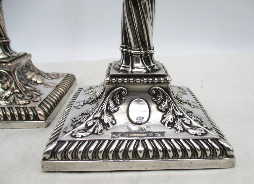 A pair of silver-plated taper candlesticks featuring spiral-fluted columns, foliage capitals, and decorative square bases. View III