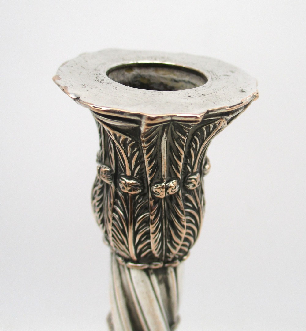 A pair of silver-plated taper candlesticks featuring spiral-fluted columns, foliage capitals, and decorative square bases. View VII