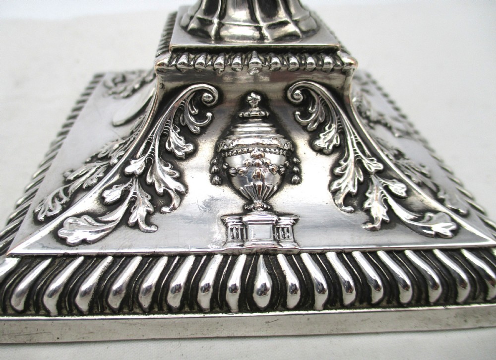 A pair of silver-plated taper candlesticks featuring spiral-fluted columns, foliage capitals, and decorative square bases. View IX