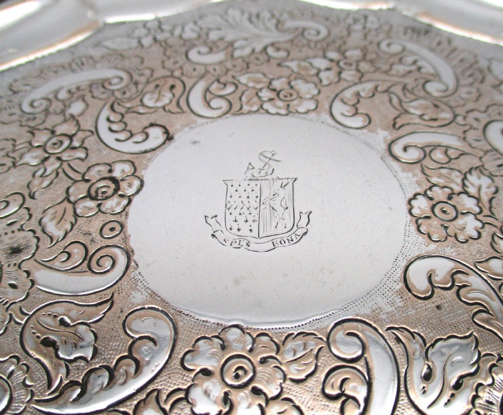 A circular Regency period Old Sheffield plated card tray featuring an engraved floral surface, armorial crest centre, pie-crust rim, and rope-twist border. View IV