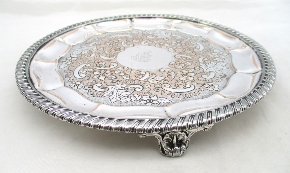 A circular Regency period Old Sheffield plated card tray featuring an engraved floral surface, armorial crest centre, pie-crust rim, and rope-twist border. View VI