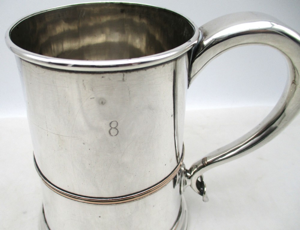 A Georgian Old Sheffield silver-plated quart tankard featuring a tapered body with a central girdle, moulded foot, and C-scroll handle. View II