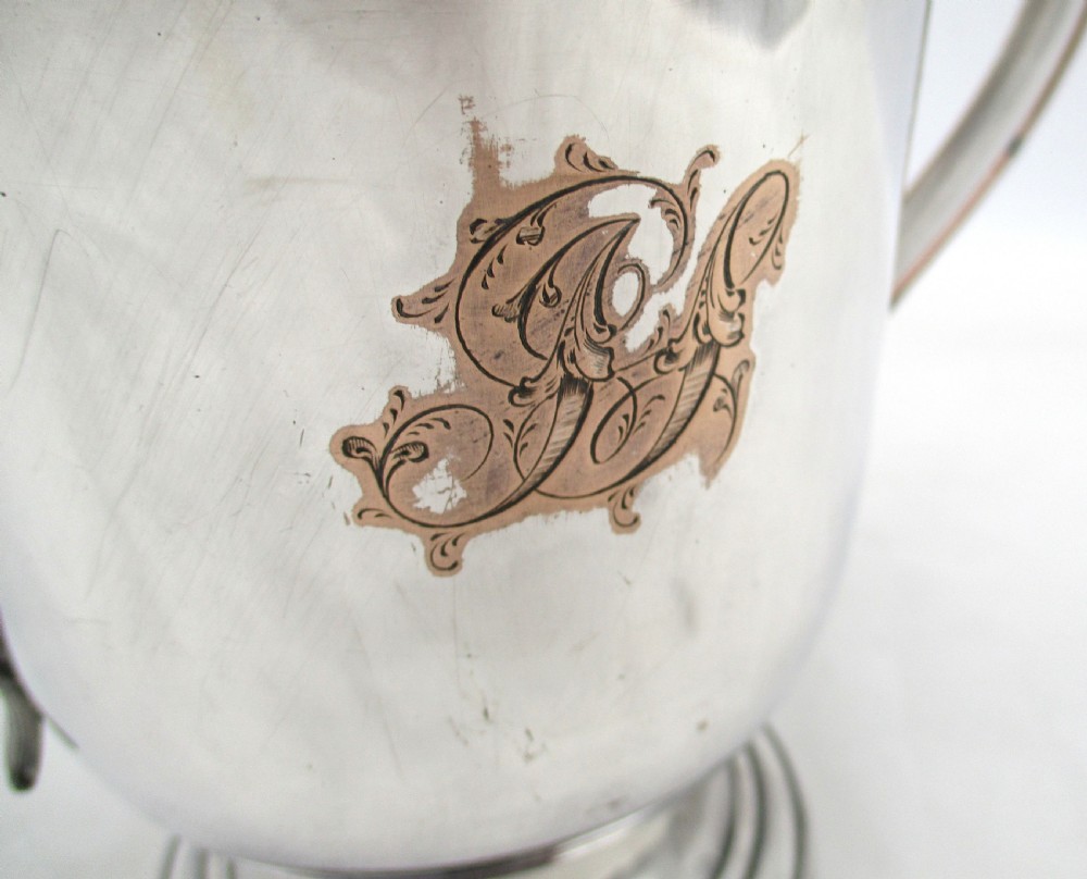 A Georgian silver-plated two-handled cup featuring a flared pedestal foot, looped side handles, and a central engraved crest. View II