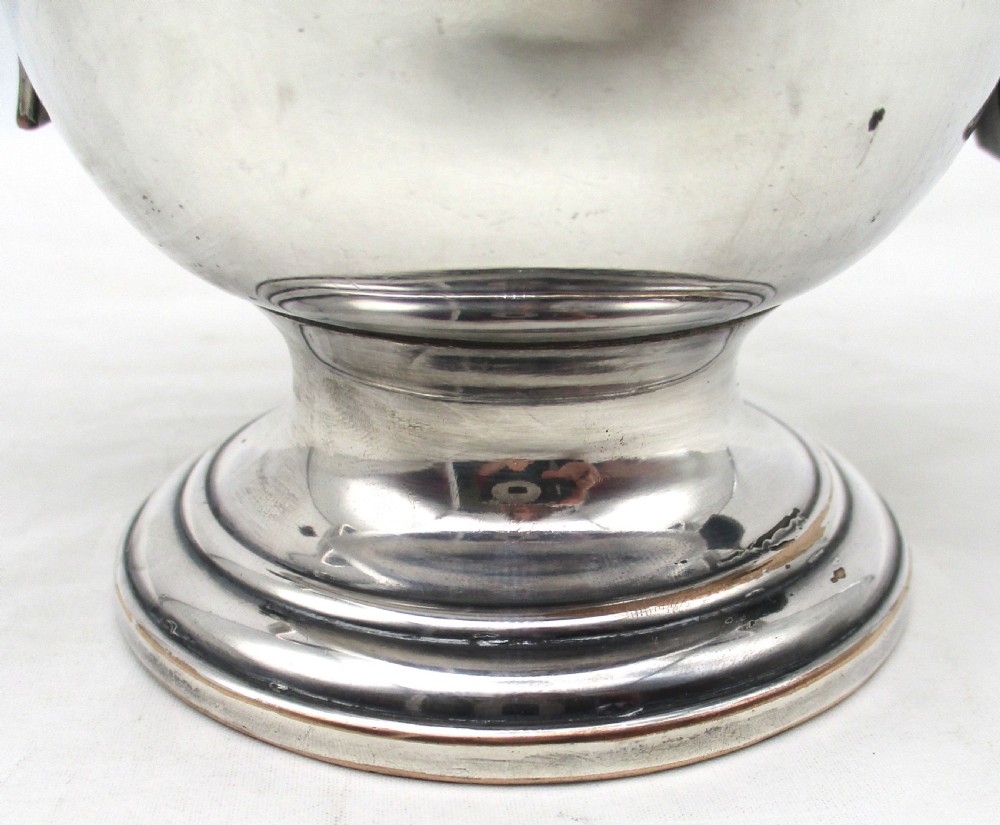 A Georgian silver-plated two-handled cup featuring a flared pedestal foot, looped side handles, and a central engraved crest. View VII