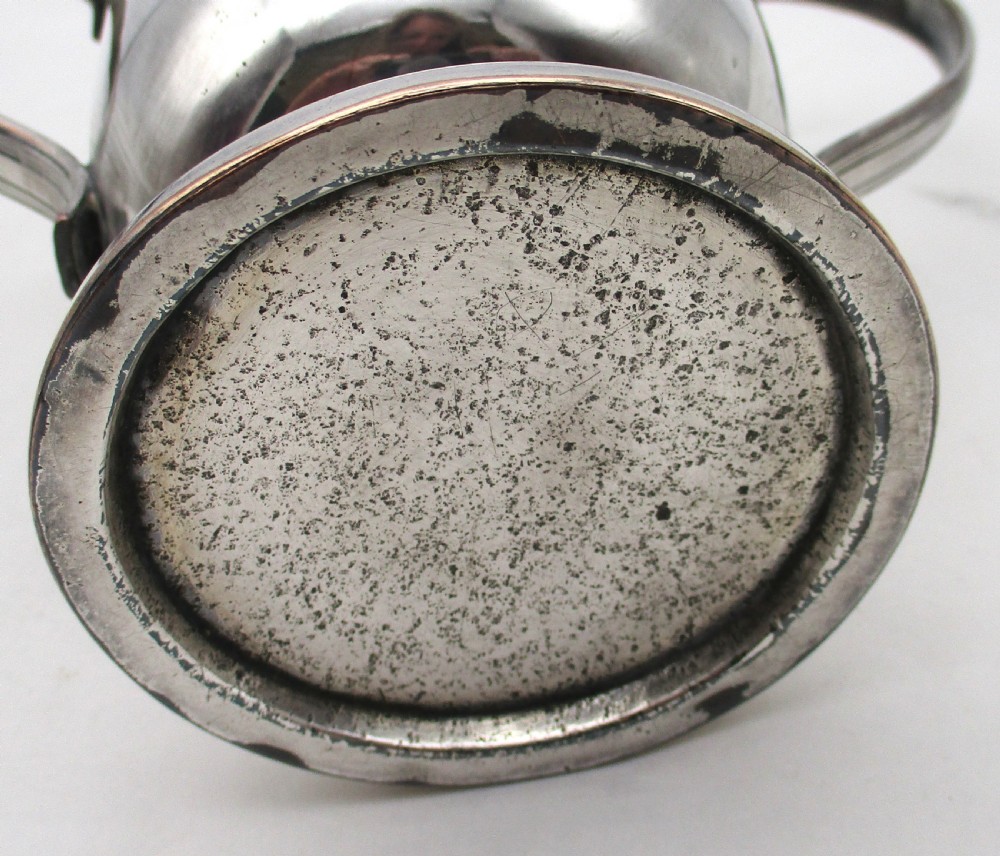 A Georgian silver-plated two-handled cup featuring a flared pedestal foot, looped side handles, and a central engraved crest. View VIII