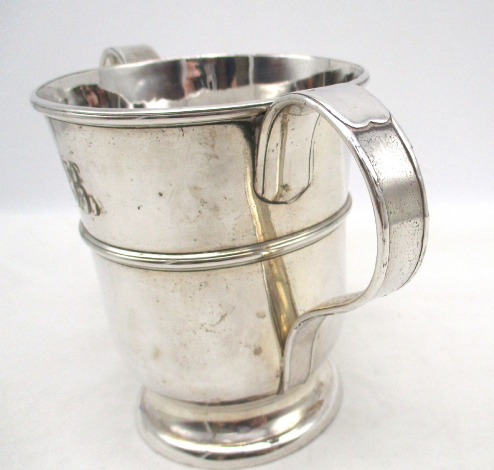 An antique silver-plated two-handled loving cup featuring a central girdle band, moulded foot, and an engraved monogram. View VI
