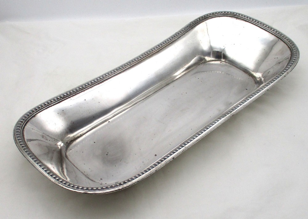 An elongated 19th-century Old Sheffield silver-plated tray featuring a rectangular form with rounded ends and a beaded outer rim.