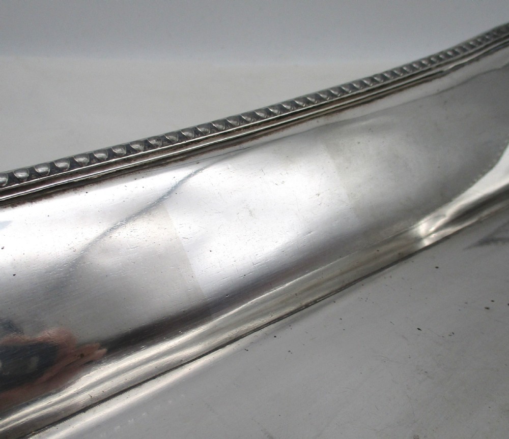 An elongated 19th-century Old Sheffield silver-plated tray featuring a rectangular form with rounded ends and a beaded outer rim. View V