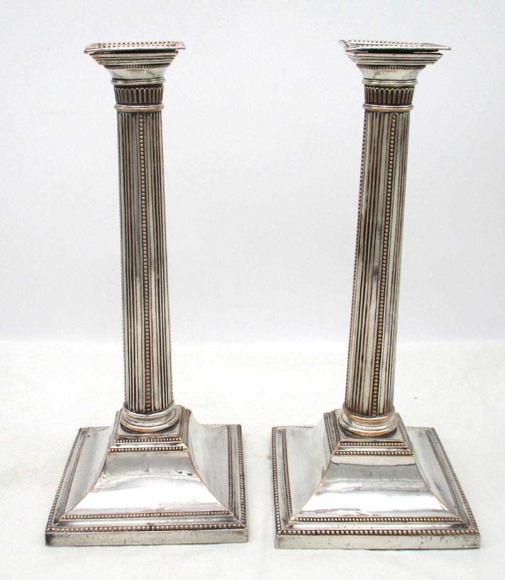 A pair of 18th-century Old Sheffield plated silver candlesticks featuring fluted columns, beaded square bases, and square nozzles. View III