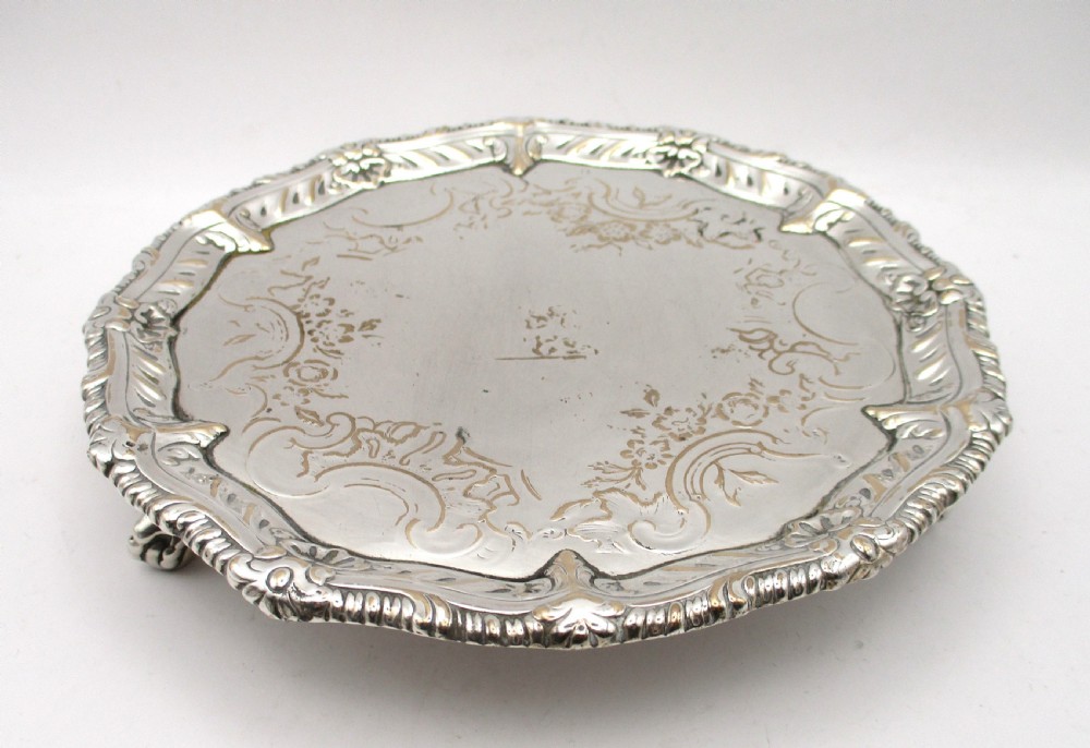 A circular Georgian Old Sheffield plated card waiter with a scalloped chased rim and etched floral scroll motifs on the surface. View II