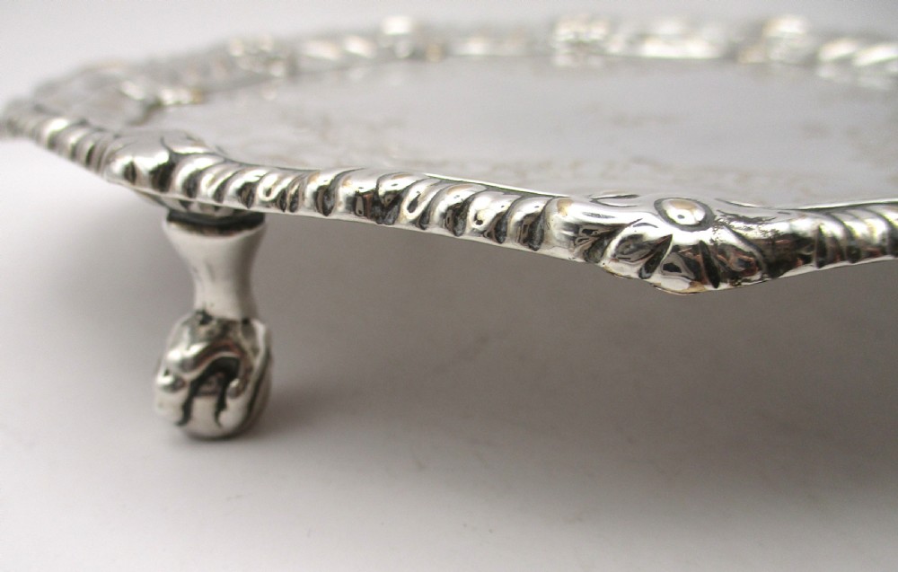 A circular Georgian Old Sheffield plated card waiter with a scalloped chased rim and etched floral scroll motifs on the surface. View V