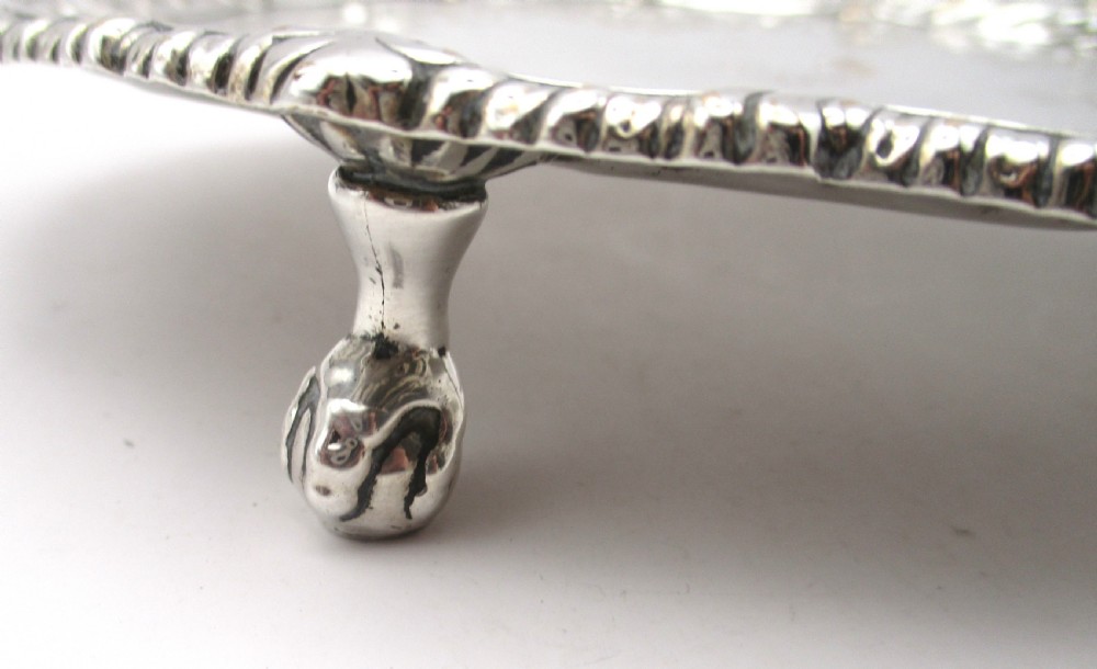 A circular Georgian Old Sheffield plated card waiter with a scalloped chased rim and etched floral scroll motifs on the surface. View VII