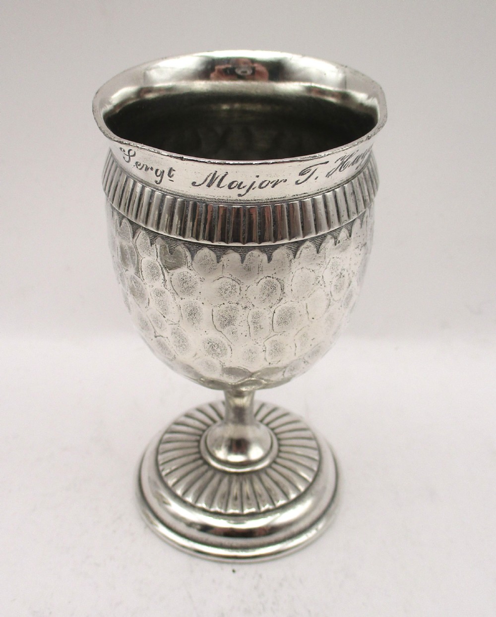 A set of four silver-plated goblets with engraved military ranks, hammered bodies, and reeded base rims. View II