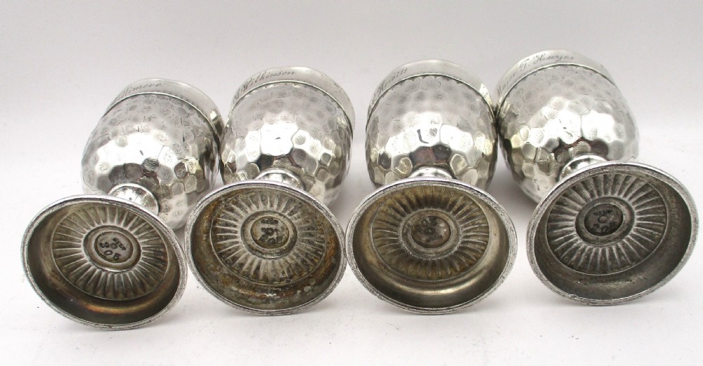 A set of four silver-plated goblets with engraved military ranks, hammered bodies, and reeded base rims. View XI