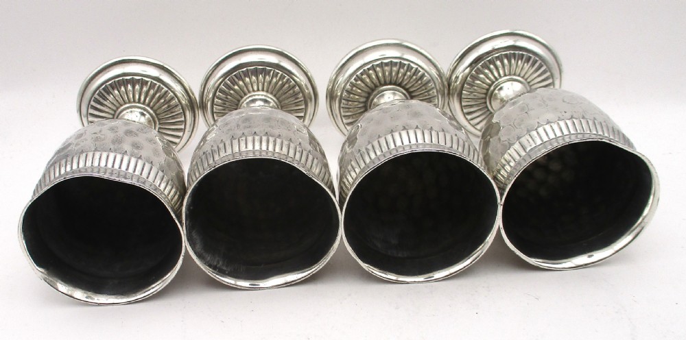A set of four silver-plated goblets with engraved military ranks, hammered bodies, and reeded base rims. View XII