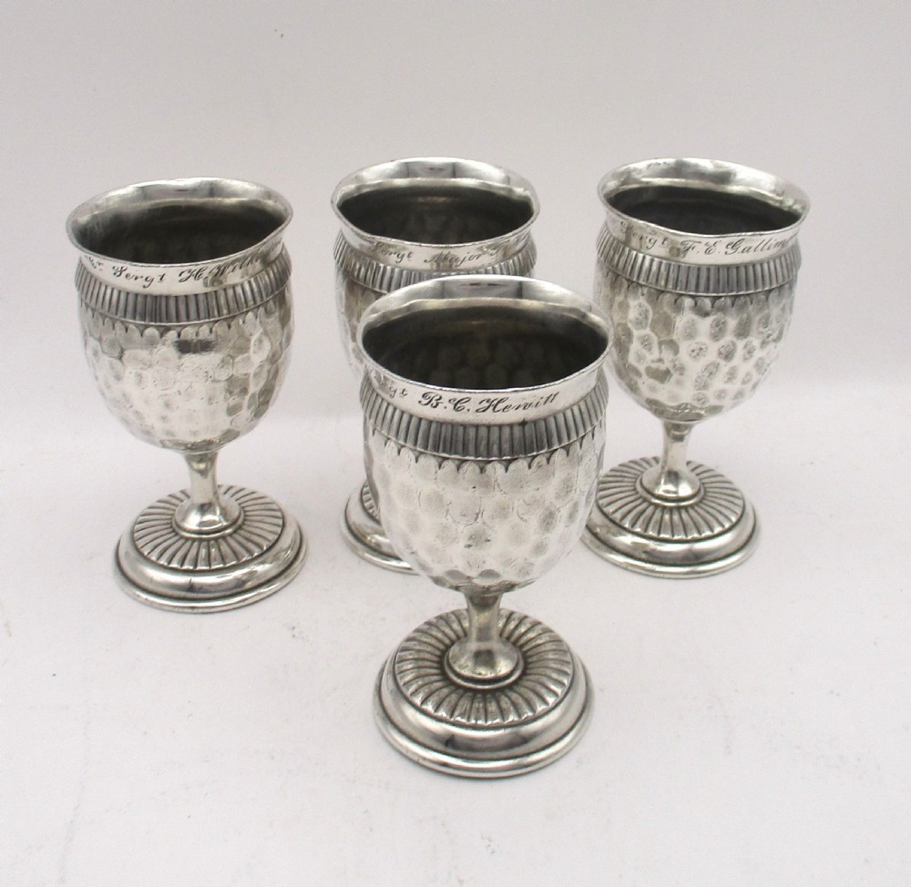 A set of four silver-plated goblets with engraved military ranks, hammered bodies, and reeded base rims. View XIII