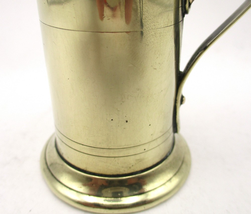 An eighteenth-century brass spice dredger featuring a perforated domed lid, a cylindrical body with moulded bands, a curved strap handle, and a stepped circular base. View VI
