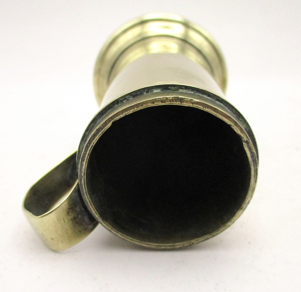 An eighteenth-century brass spice dredger featuring a perforated domed lid, a cylindrical body with moulded bands, a curved strap handle, and a stepped circular base. View XI