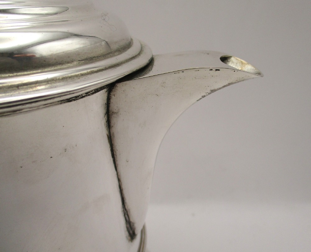An 18th-century silver-plated beer jug with a domed hinged lid, thumbpiece, spout, and curved scroll handle. View VI