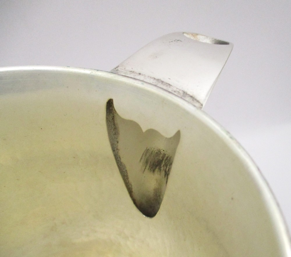 An 18th-century silver-plated beer jug with a domed hinged lid, thumbpiece, spout, and curved scroll handle. View VII
