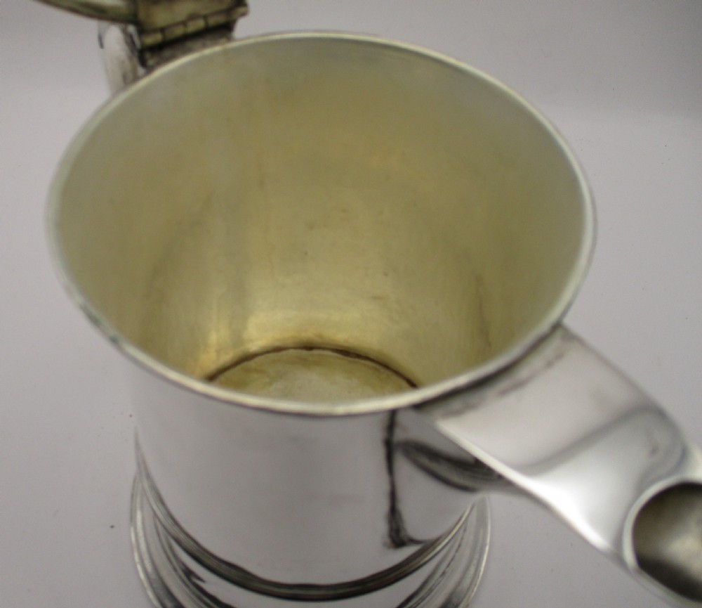 An 18th-century silver-plated beer jug with a domed hinged lid, thumbpiece, spout, and curved scroll handle. View VIII