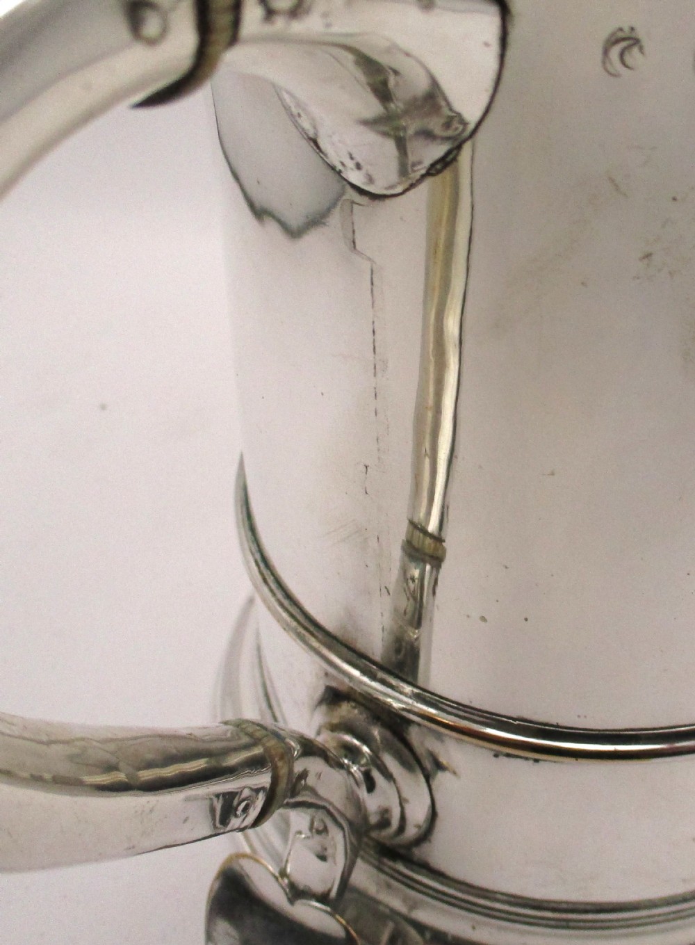 An 18th-century silver-plated beer jug with a domed hinged lid, thumbpiece, spout, and curved scroll handle. View IX