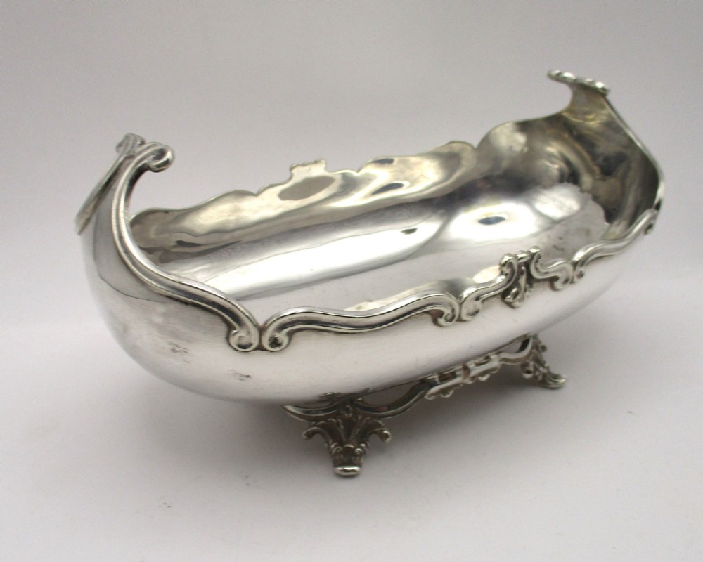 An Art Nouveau silver-plated boat-shaped bonbon dish featuring curved side handles, a decorative scrolled rim, and four cast scroll feet. View II