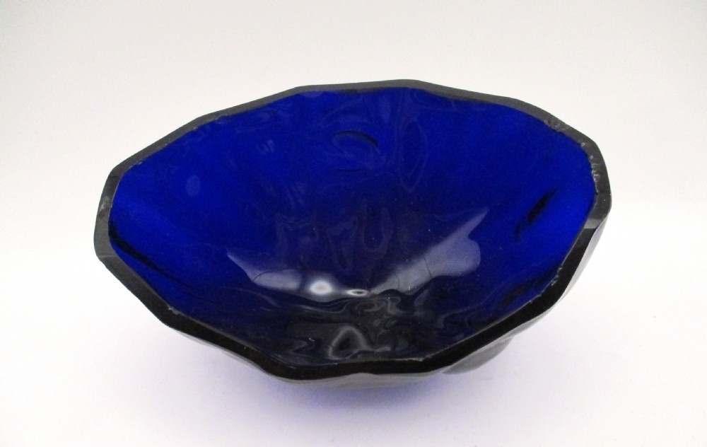 A Georgian Sheffield plated silver wirework sugar basket featuring an oval engraved cartouche, overhead handle, pedestal foot, and cobalt blue glass liner. View XII