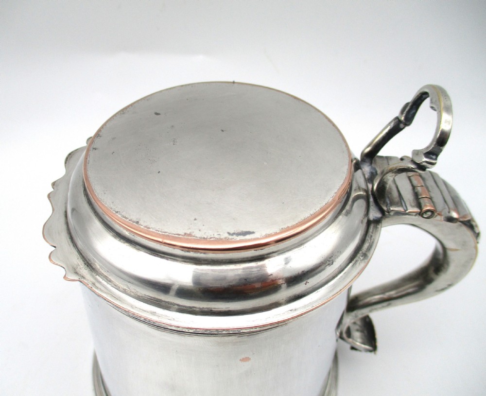 A late 18th-century silver-plated pint tankard featuring a hinged stepped lid, thumbpiece lever, curved scroll handle, and subtle copper exposure along worn rim edges. View II