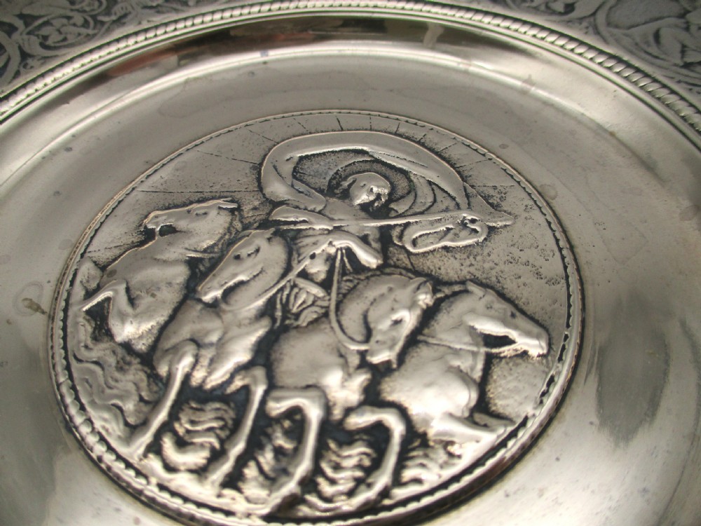 A circular 19th-century bronze platter featuring a central relief of a classical chariot and an ornate outer rim detailed with mythological figures and grotesques. View VII