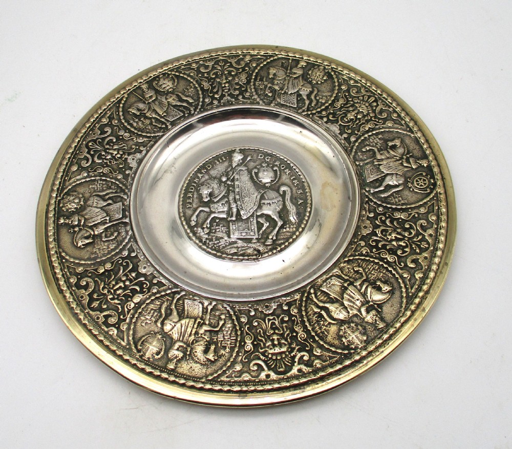 A circular 19th-century silver-plated bronze platter featuring a central relief profile of Emperor Ferdinand III on horseback surrounded by detailed equestrian vignettes and ornate scrolling foliage. View II