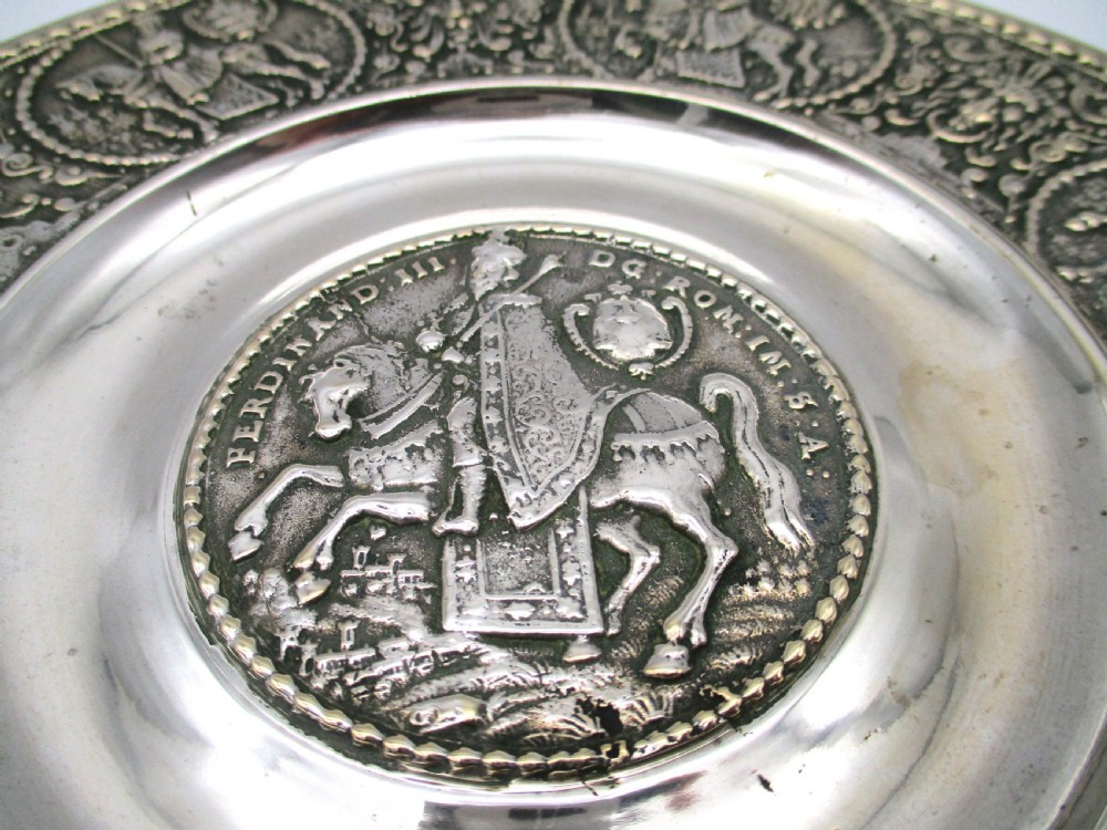 A circular 19th-century silver-plated bronze platter featuring a central relief profile of Emperor Ferdinand III on horseback surrounded by detailed equestrian vignettes and ornate scrolling foliage. View III
