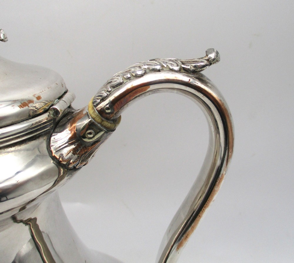 A Regency period Old Sheffield plated silver coffee pot featuring a baluster-shaped body, goose-neck spout, foliate finial, and scroll handle with heat insulators. View III