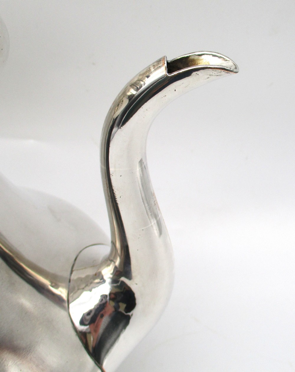 A Regency period Old Sheffield plated silver coffee pot featuring a baluster-shaped body, goose-neck spout, foliate finial, and scroll handle with heat insulators. View V