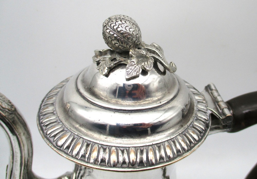 An eighteenth-century Sheffield silver-plated coffee pot featuring a baluster body, carved dark wood handle, fluted spout, and pineapple finial. View IV