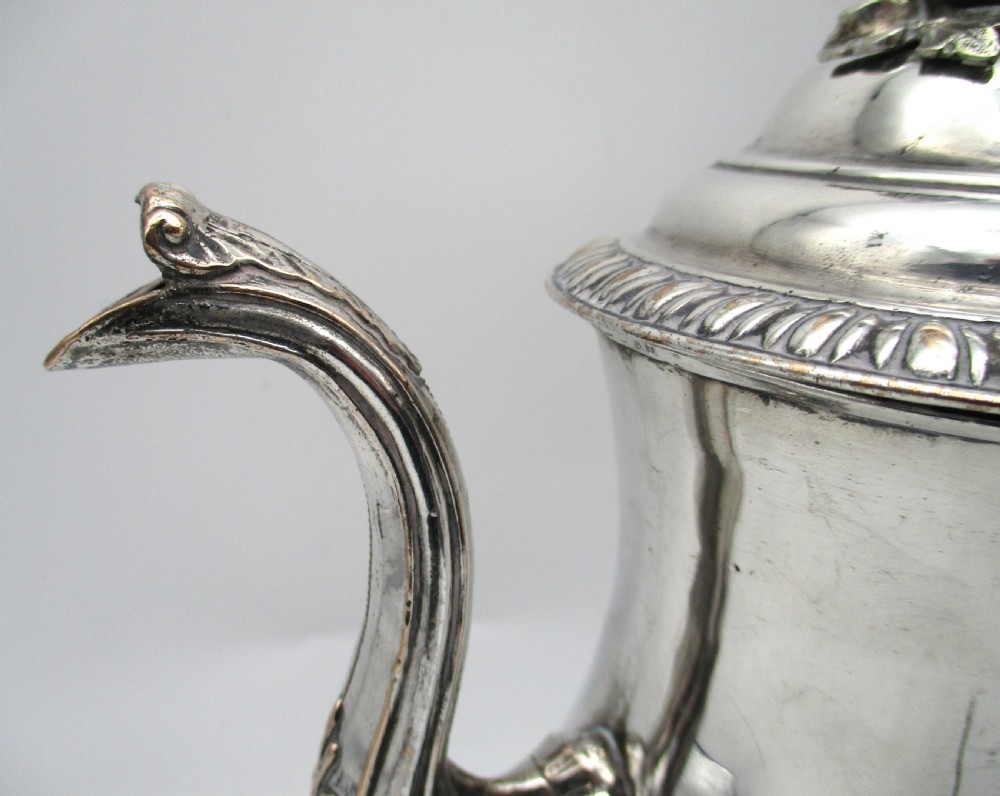 An eighteenth-century Sheffield silver-plated coffee pot featuring a baluster body, carved dark wood handle, fluted spout, and pineapple finial. View V