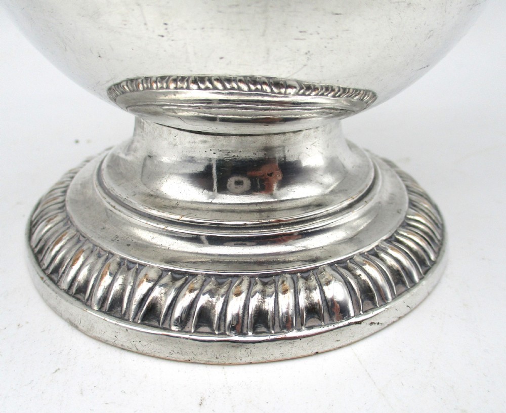 An eighteenth-century Sheffield silver-plated coffee pot featuring a baluster body, carved dark wood handle, fluted spout, and pineapple finial. View VI