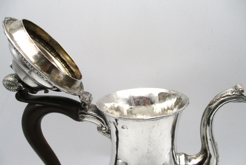 An eighteenth-century Sheffield silver-plated coffee pot featuring a baluster body, carved dark wood handle, fluted spout, and pineapple finial. View X